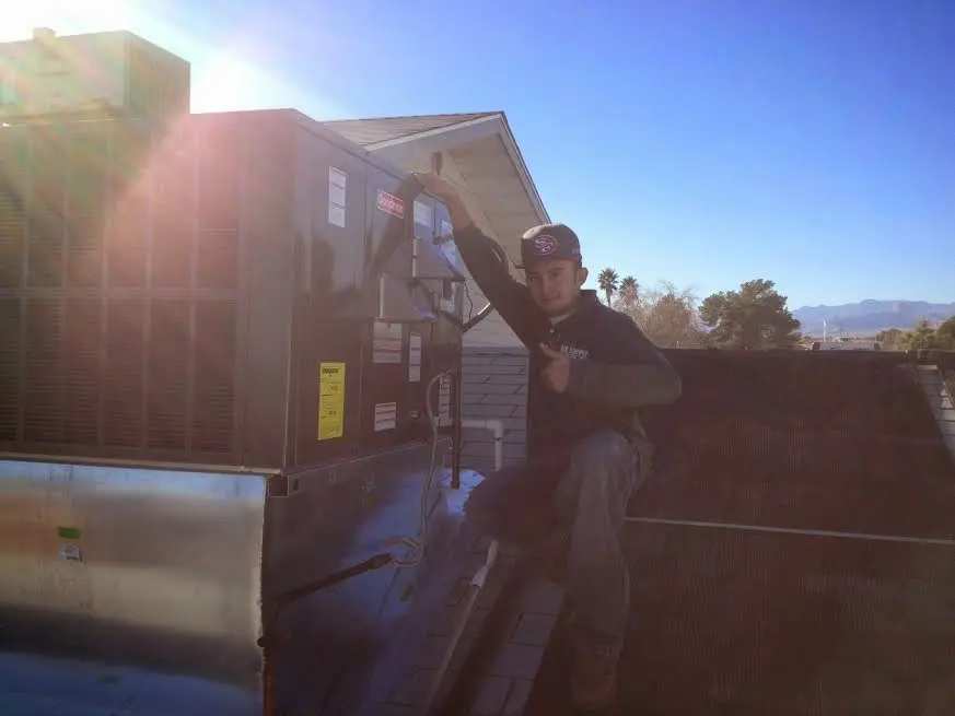 HVAC technician performing AC Tune-Up on a rooftop unit in Baldwin
